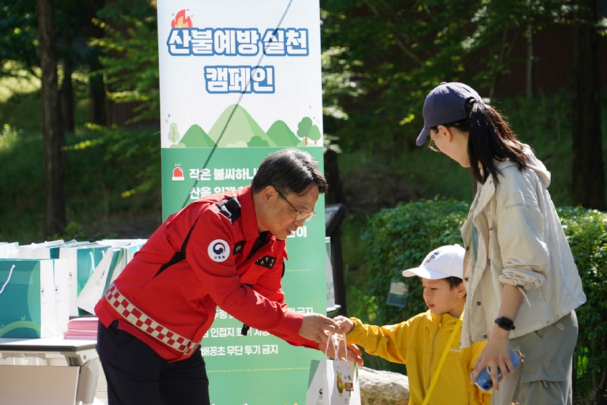 사진4.박은식 산림청장(왼쪽)이 5일 어린이날 국립대전숲체원에서 가족단위 나들이객을 대상으로 산불예방 홍보활동을 하고있다..jpg